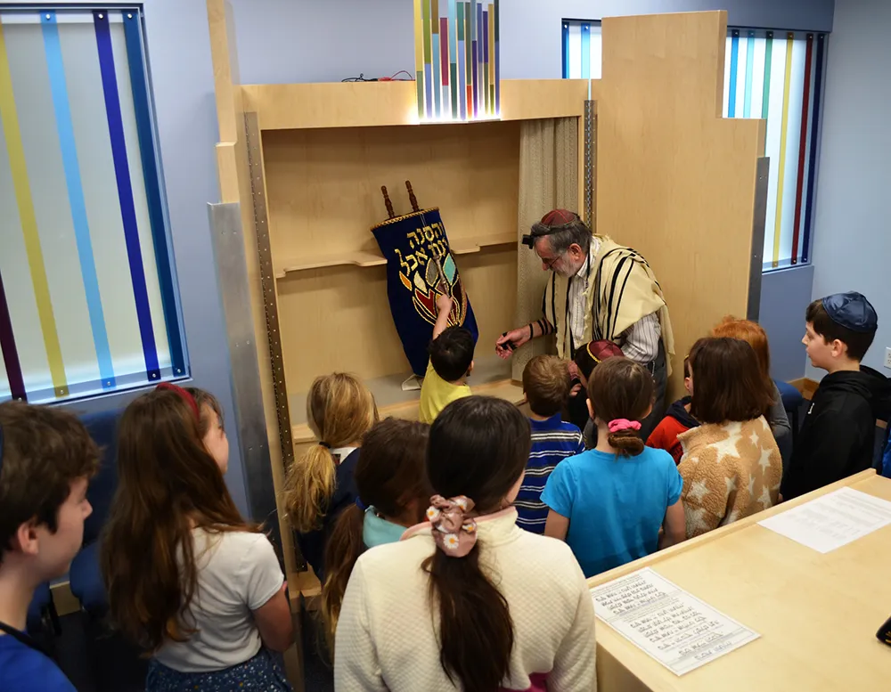 rabbi showing a group of kids the torah