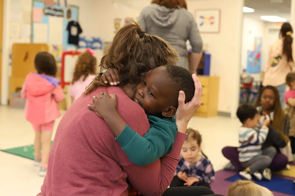 young boy hugging his teacher