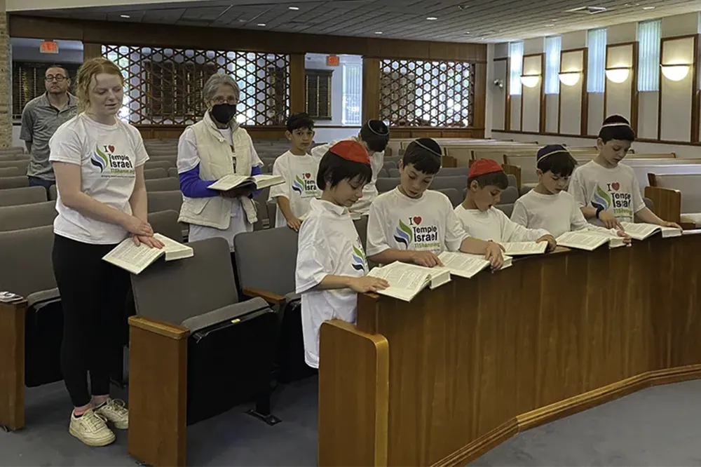 children in masks standing in synagogue