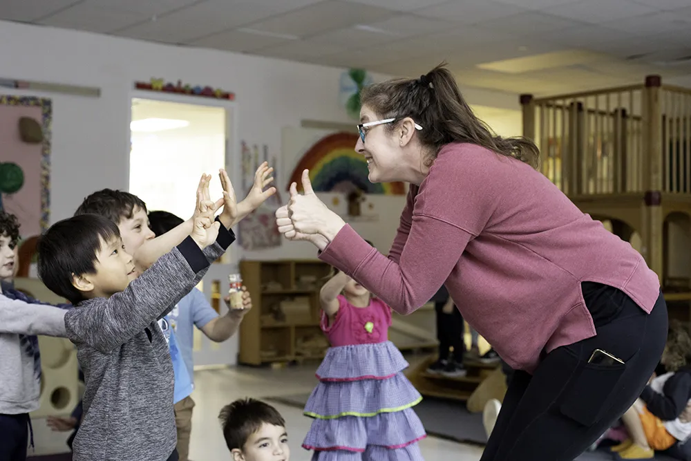 teacher giving excited nursery school kids a thumbs up